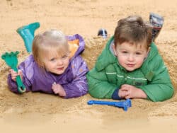 Two young children playing in the sand at Juniors Day Nursery.