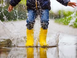 Pre-school child splashing in the puddles at Juniors Day Nursery.