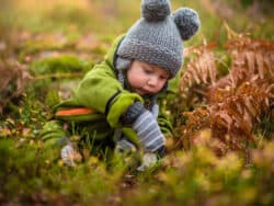 Child playing outside in the winter at Juniors Day Nursery.