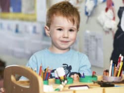 Boy at the drawing table at Juniors Day Nursery.