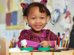 Girl by the drawing desk at Juniors Day Nursery.