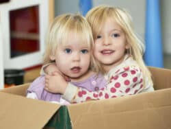 Sisters playing in a box at Juniors Day Nursery.