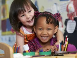 Two young girls by the drawing desk at Juniors Day Nursery.