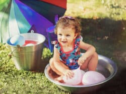 Young girl playing in water at Juniors Day Nursery.