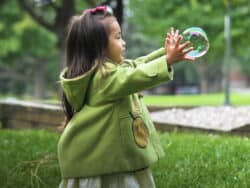 Young girl playing with bubbles at Juniors Day Nursery.