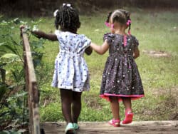 Two young girls playing in the garden at Juniors Day Nursery.