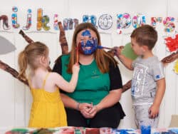 Children painting the face of a key worker at Juniors Day Nursery.