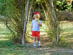 Child exploring in the garden at Juniors Day Nursery.