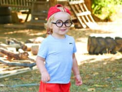 Pre-school children dressing up in the garden at Juniors Day Nursery.