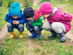 Three children exploring the ground at Juniors Day Nursery.
