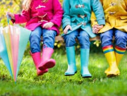 Three young children in wellington boots at Juniors Day Nursery.
