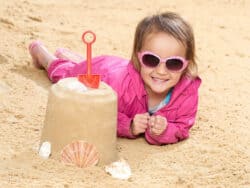 Young girl playing in sand at Juniors Day Nursery.