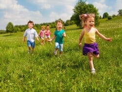 Five children running outside Juniors Day Nursery.