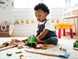 Toddler playing with trains at Juniors Day Nursery.